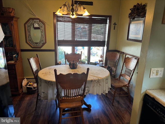 dining room with dark wood-type flooring and an inviting chandelier