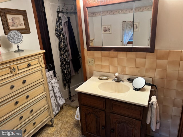 bathroom with tile walls, vanity, and backsplash