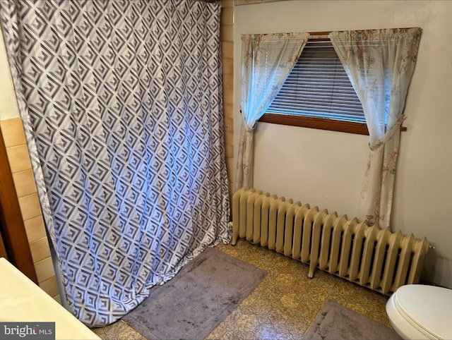 bathroom featuring toilet and radiator heating unit