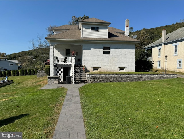 rear view of property featuring a yard