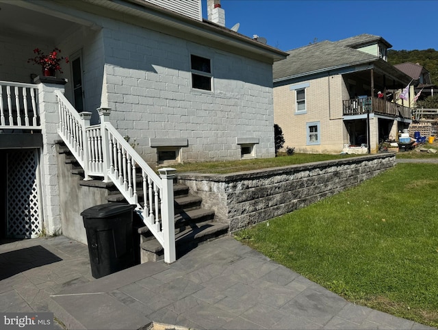 view of side of home featuring a yard and a patio area