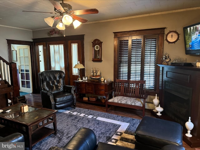 living room featuring ceiling fan, ornamental molding, and dark hardwood / wood-style floors