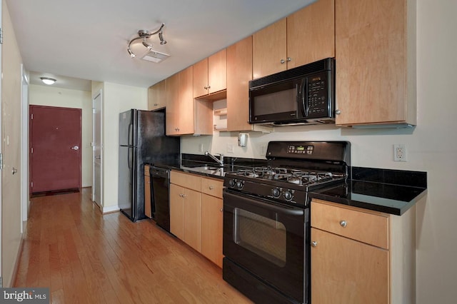 kitchen featuring light hardwood / wood-style floors, light brown cabinets, black appliances, and sink