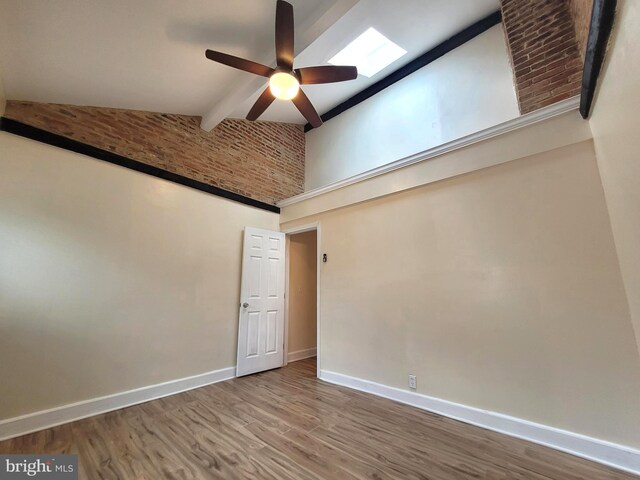 empty room featuring beamed ceiling, hardwood / wood-style flooring, high vaulted ceiling, and ceiling fan