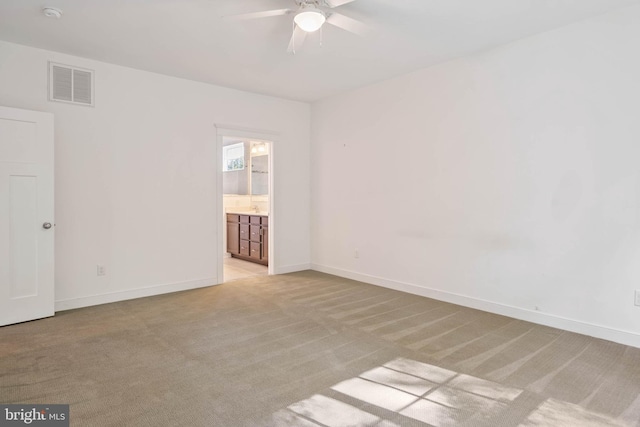 empty room featuring light colored carpet and ceiling fan