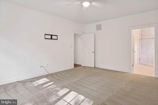 carpeted spare room featuring ceiling fan