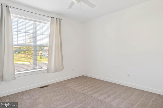 carpeted spare room featuring ceiling fan