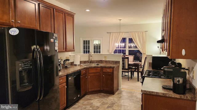 kitchen featuring kitchen peninsula, an inviting chandelier, black appliances, sink, and decorative light fixtures