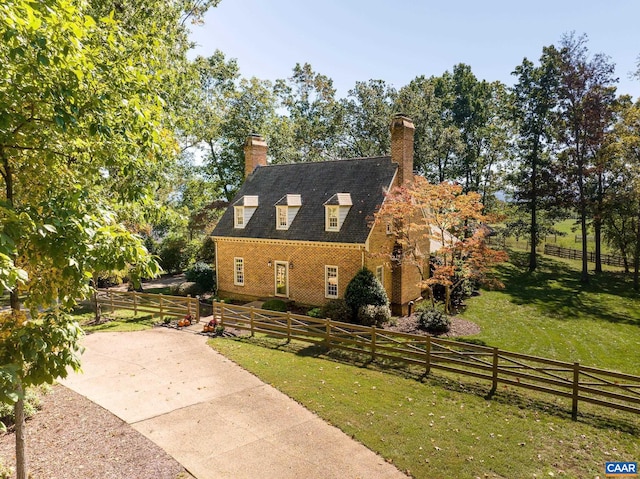 view of home's exterior with a rural view and a yard