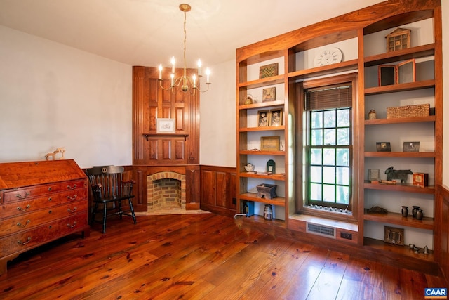 living area featuring a fireplace, a chandelier, and dark hardwood / wood-style flooring