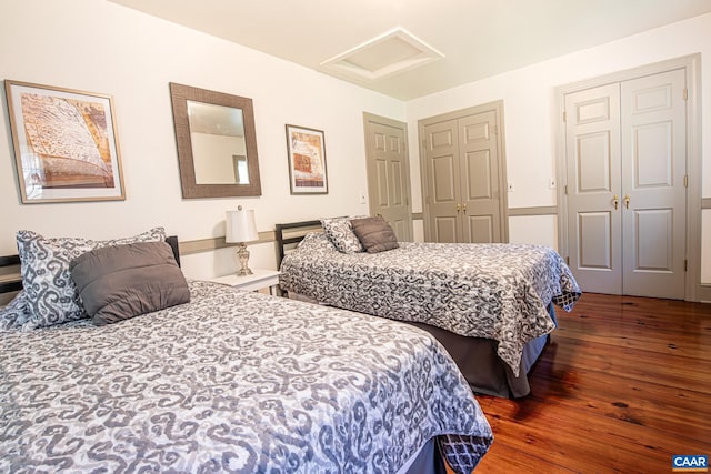 bedroom featuring dark hardwood / wood-style floors and two closets