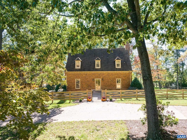 cape cod-style house featuring a front yard