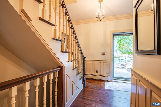 entrance foyer with dark hardwood / wood-style floors, a chandelier, a baseboard heating unit, and ornamental molding