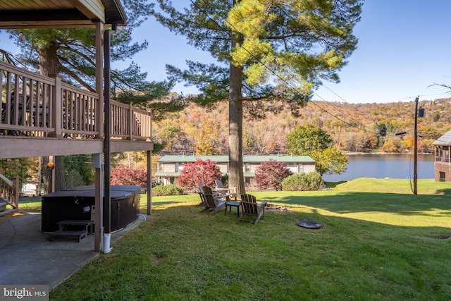 view of yard with a hot tub and a water view