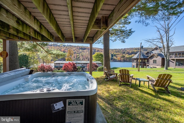 view of yard with a hot tub and a water view