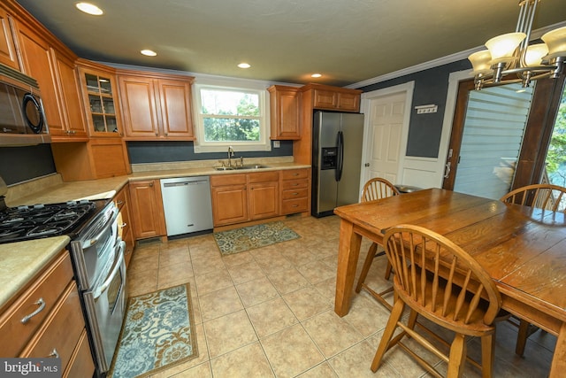 kitchen featuring sink, crown molding, decorative light fixtures, light tile patterned floors, and stainless steel appliances