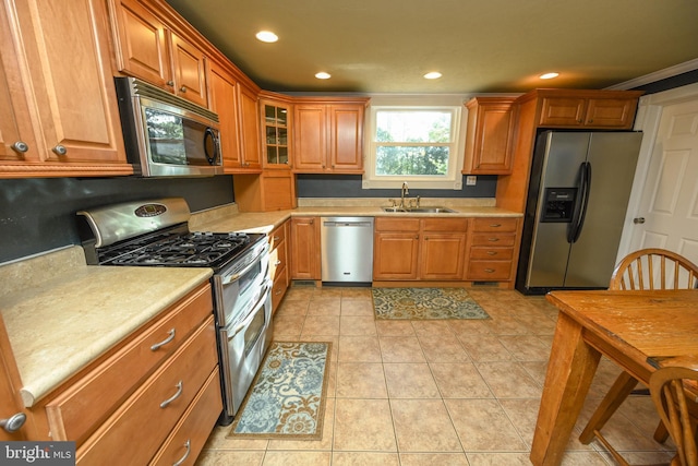 kitchen featuring stainless steel appliances, sink, and light tile patterned floors