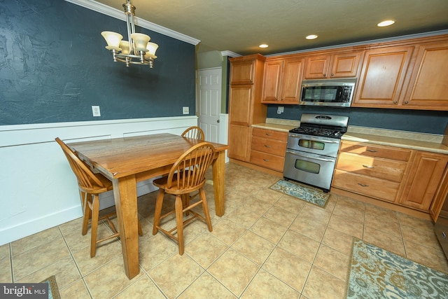 kitchen featuring appliances with stainless steel finishes, ornamental molding, light tile patterned flooring, decorative light fixtures, and a chandelier