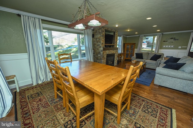 dining room with crown molding, dark wood-type flooring, and a wealth of natural light