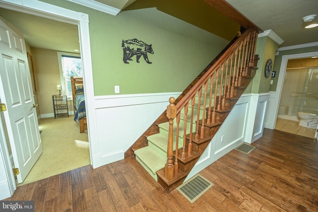 stairway featuring hardwood / wood-style flooring and crown molding