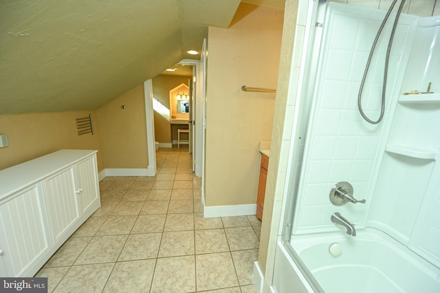 bathroom with vaulted ceiling, vanity,  shower combination, and tile patterned flooring