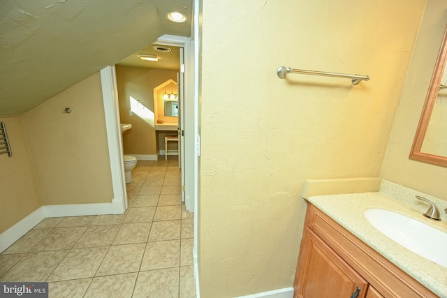 bathroom featuring tile patterned flooring, vanity, lofted ceiling, and toilet