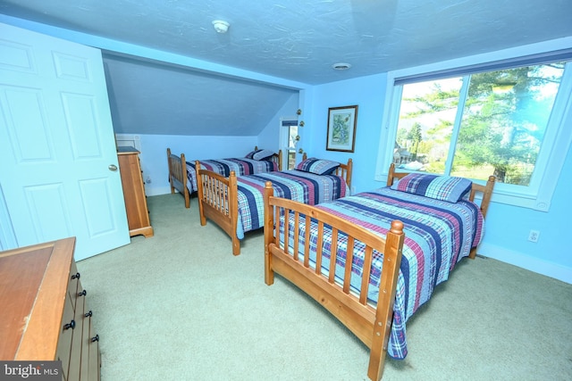 carpeted bedroom with lofted ceiling and a textured ceiling