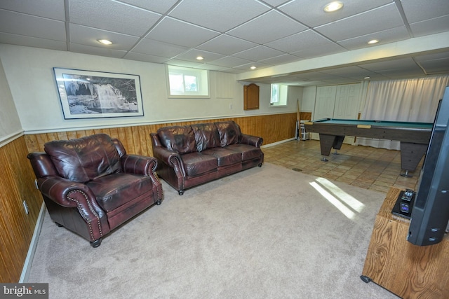 carpeted living room featuring a drop ceiling, wooden walls, and billiards