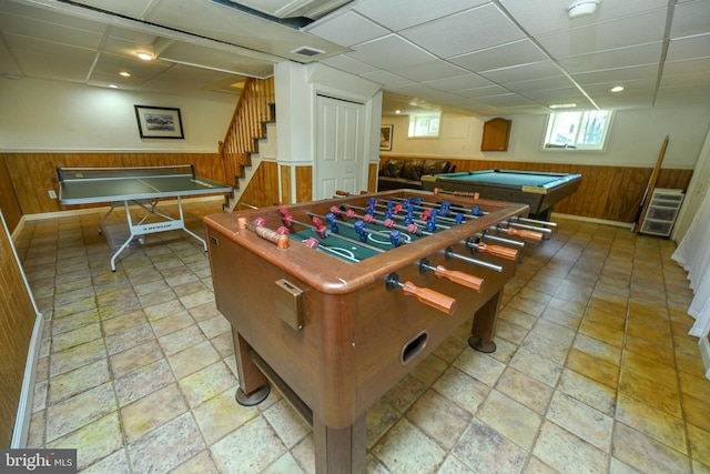 game room featuring a drop ceiling, pool table, and wooden walls