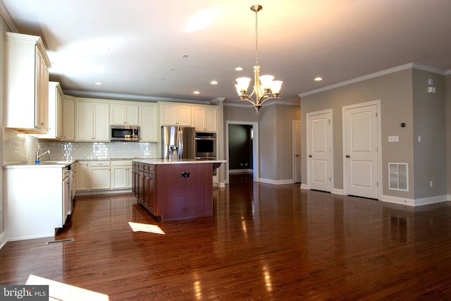 kitchen with appliances with stainless steel finishes, decorative light fixtures, a center island, and dark wood-type flooring