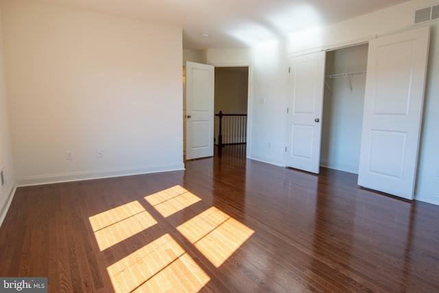 unfurnished bedroom featuring dark hardwood / wood-style floors and a closet