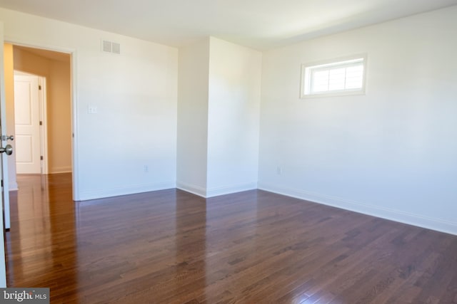 unfurnished room with dark wood-type flooring