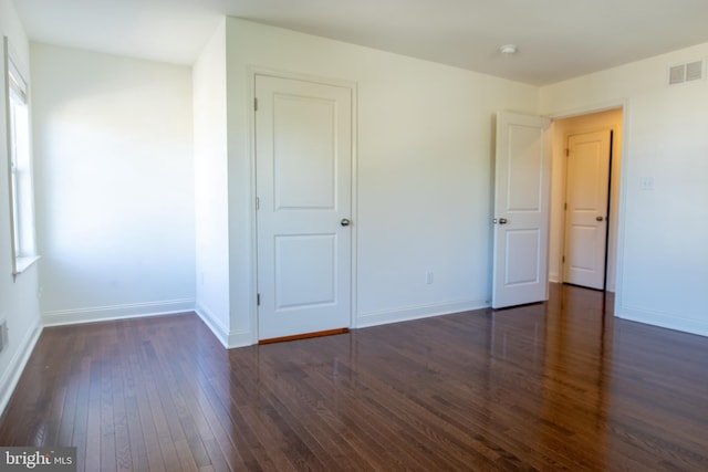 unfurnished bedroom with dark hardwood / wood-style flooring