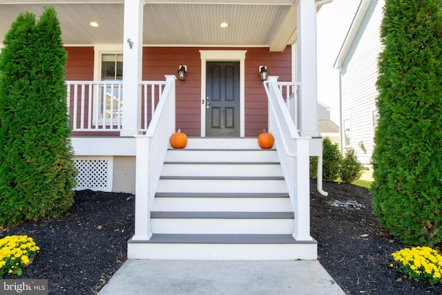 view of exterior entry featuring covered porch