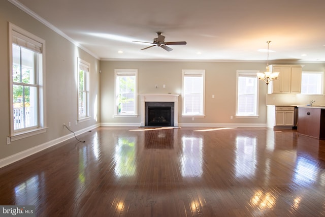 unfurnished living room featuring ceiling fan with notable chandelier, ornamental molding, sink, and dark hardwood / wood-style floors