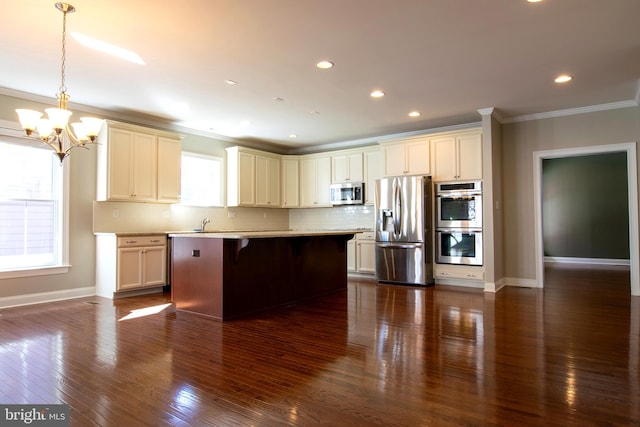 kitchen featuring appliances with stainless steel finishes, a kitchen bar, dark hardwood / wood-style floors, ornamental molding, and decorative light fixtures