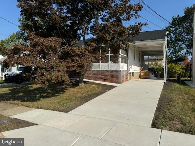 view of side of property featuring a carport and a lawn