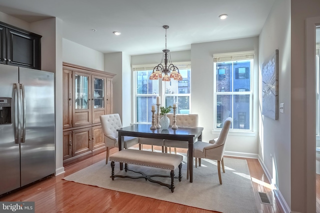 dining area featuring a notable chandelier and light wood-type flooring