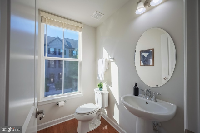 bathroom with toilet, sink, and wood-type flooring