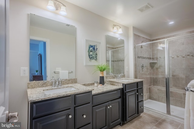 bathroom featuring vanity, an enclosed shower, and tile patterned flooring