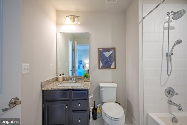 full bathroom featuring vanity, tiled shower / bath combo, and toilet