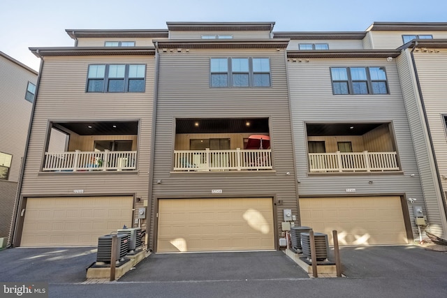 multi unit property with cooling unit, a balcony, and a garage