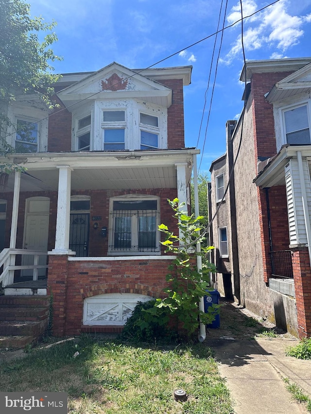 view of front facade with a porch and brick siding