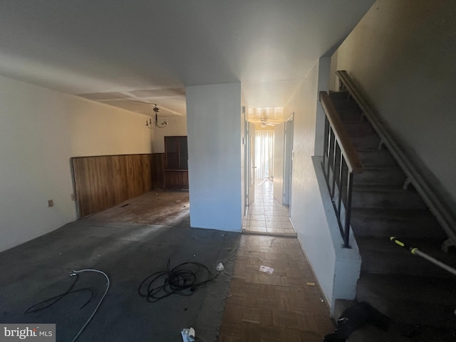 interior space featuring a notable chandelier, wooden walls, and parquet floors