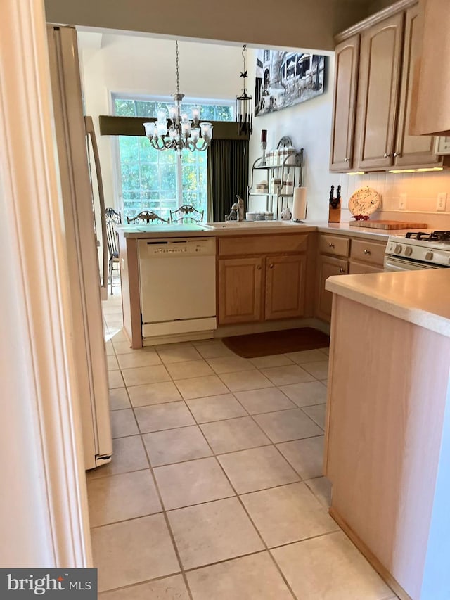 kitchen with light brown cabinetry, white appliances, light tile patterned floors, pendant lighting, and a chandelier