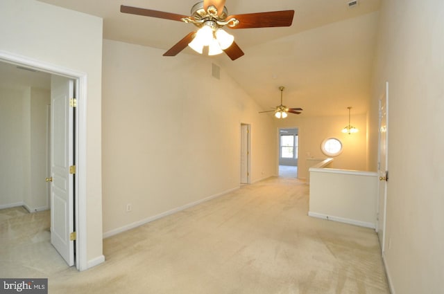 carpeted spare room with ceiling fan with notable chandelier and high vaulted ceiling