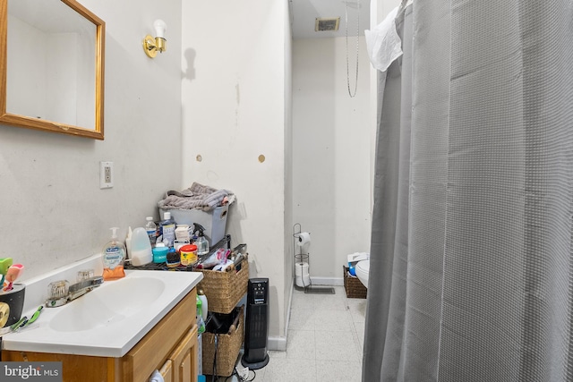 bathroom featuring toilet, vanity, and a shower with curtain