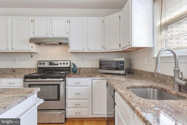 kitchen with light stone counters, sink, stainless steel appliances, and white cabinets