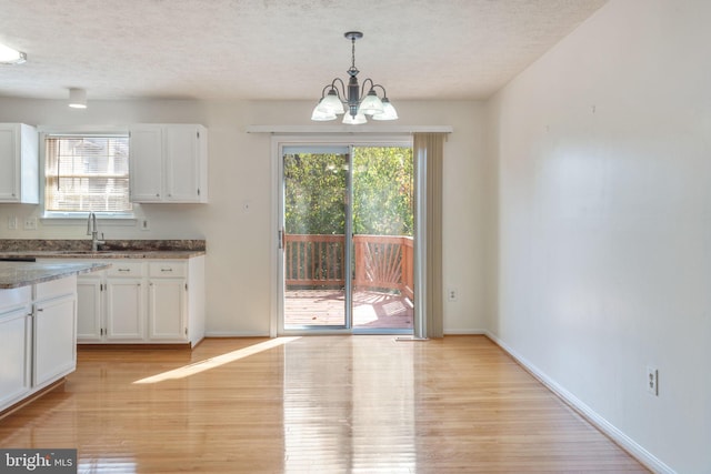 kitchen with hanging light fixtures, white cabinets, and a chandelier