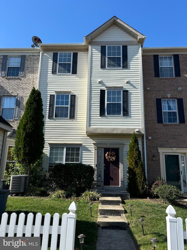 view of property with a front yard and central AC unit